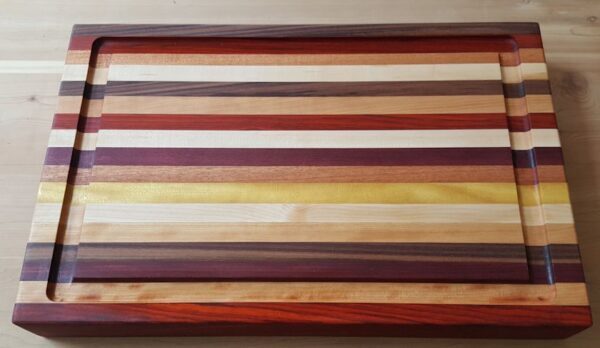 Multi-colored cutting board with juice groove